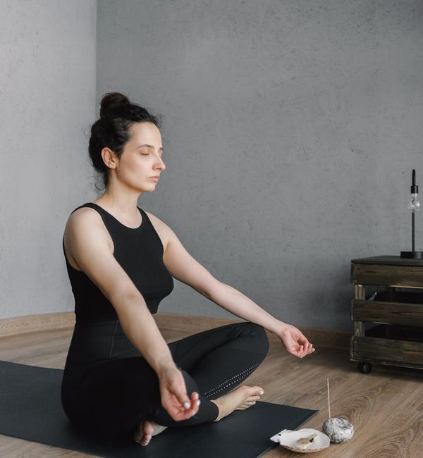 Person meditating peacefully in a calm and minimalist room.
