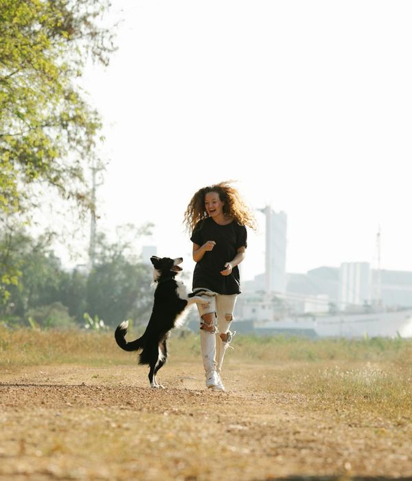 Woman feeling energetic and happy outdoors in a sunny park.